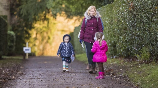 Two children and an adult walking down a path in the Hanbury Hall gardens